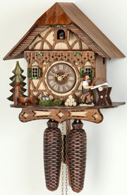 Original 8 Day Cuckoo Clock in a Chalet Style, beautiful scene with a tree, water and a wood cutter sawing wood.